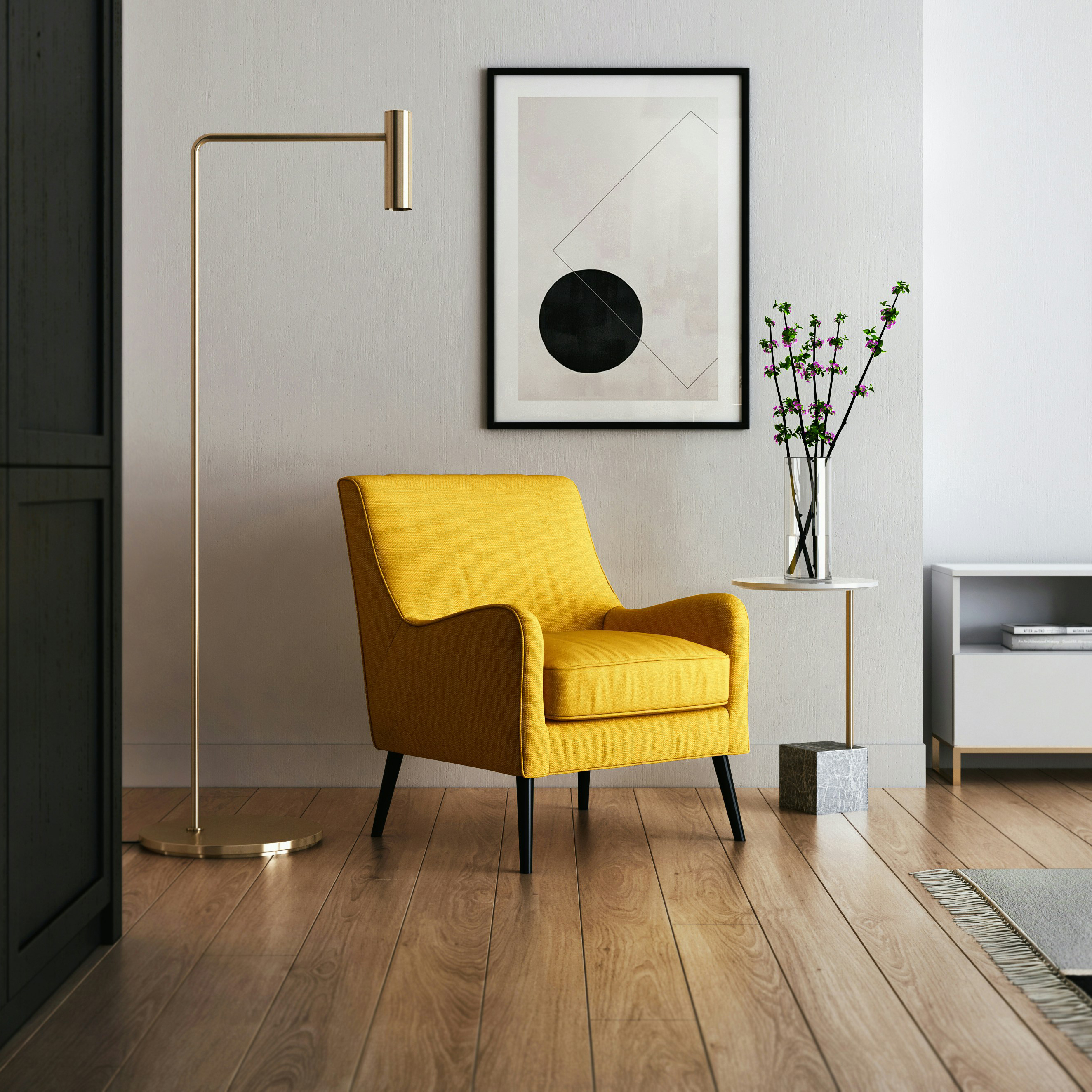 A staged photo; showing a yellow chair, modern gold floor lamp, a side table with a vase of flowers, and a bold black and white graphic art piece hanging on the wall.